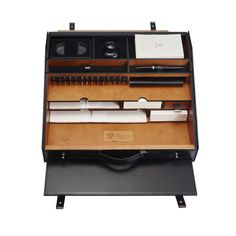 an open drawer with pens, pencils and other items in it on a white background