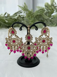 Kundan jewelry set includes a pair of earrings and a tikka. Colour: hot pink Party Hand Set Tikka, Pink Bollywood Jewelry, Pink Hand Set Earrings For Celebration, Bollywood Style Pink Tikka With Stone Work, Pink Stone Work Tikka As Gift, Festive Pink Hand Set Bridal Earrings, Pink Bridal Earrings For Festive Occasion, Pink Bridal Earrings For Festive Wedding, Pink Danglers For Wedding