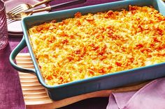 a casserole dish with cheese and meat in it on a purple cloth next to silverware