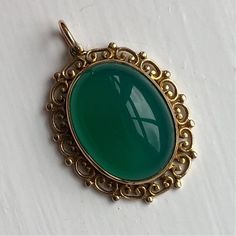 "A vintage 9 carat gold pendant displaying a green jadeite stone. A beautiful ornate design creates a lovely piece. CONDITION: Great condition, wear consistent with it's age and use. Please see photos for more detail. MARKED 9 CARAT GOLD  WEIGHT: 5.4 grams STONE (FACE): 19mm x 15mm STONE AND SETTING HEIGHT: 8mm ORNATE \"FRAME\": 4mm MEASUREMENT (DROP INC. LOOP): 34mm" Green Oval Heirloom Jewelry, Antique May Birthstone Jewelry For Formal Occasions, Heirloom Oval Green Jewelry, Heirloom Green Oval Jewelry, Vintage Green Oval Cabochon Jewelry, Vintage Hallmarked Emerald Jewelry, Vintage Oval Emerald Jewelry, Vintage Yellow Gold May Birthstone Jewelry, Vintage Oval May Birthstone Jewelry