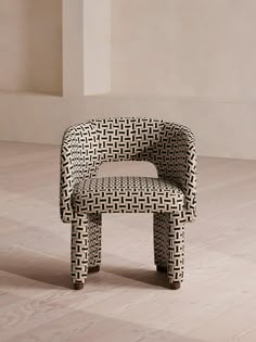 a black and white chair sitting on top of a hard wood floor