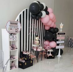 a black and white striped room with balloons, cake table and desserts on display