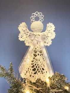 an angel decoration on top of a christmas tree