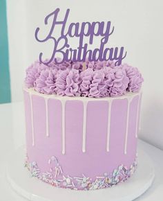 a birthday cake with purple frosting and sprinkles on the top that says happy birthday