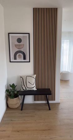 a black and white bench sitting in front of a wall with vertical striped panels on it