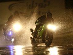 two motorcyclists riding in the rain on their bikes at night with text overlay