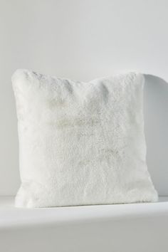 a white pillow sitting on top of a bed