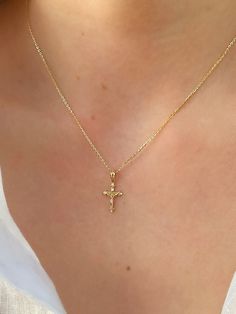 This unique dainty Crucifix Cross Necklace features a small gold cross with a high polish finish that sits on a delicate 14K Yellow Gold chain. It's perfect for layering with your favorites or styled solo for a classic look. Necklace Length: 16 Inches *with a 2-inch extension Pendant Length: 1.6 cm * Bail: 0.4 cm Pendant Width: 1 cm Chain Type: Flat Cable Clasp: Lobster Metal: 14K Yellow Gold (stamped) Good Cross Necklace, Small Gold Cross Necklace, Gold Jewelry Cross, Gold Cross Necklace Aesthetic, Crucifix Necklace Women, Cross Necklace Aesthetic, Cross Gold Necklace, Gold Cross Necklace For Women, Orthodox Cross Necklace