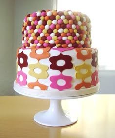 there is a multi layer cake with colorful decorations on the top and bottom tiers