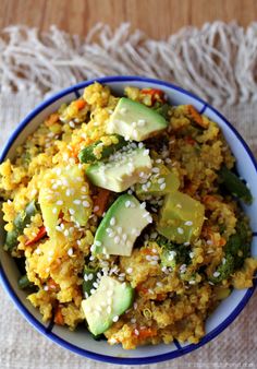 a bowl filled with rice and vegetables on top of a table