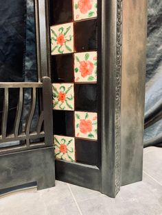 an ornate metal fireplace with flowers painted on it