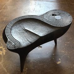 a wooden table with an intricate design on it's surface, sitting on the floor