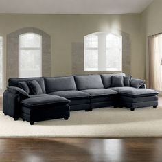 a living room with a sectional couch and ottoman