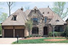 a large brick house with two garages on the front and one story above it