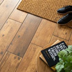 a close up of a wooden floor with a plant on the ground next to it