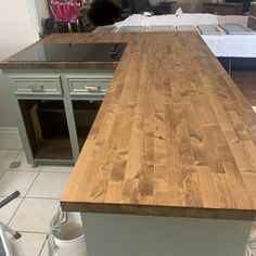 a kitchen island made out of wood in the middle of a room with other appliances