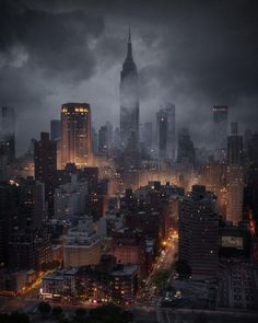 an aerial view of a city at night with the lights on and dark clouds in the sky