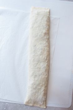 a piece of bread sitting on top of a white cutting board next to a knife