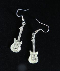 "Electric Guitar Earrings Oxidized Matte Silver. They measure approx. 1/2\" by 1-1/2\". I only use Surgical Steel Ear Posts or Wires for all my Earrings. More can wear these over all others. Great for Sensitive ears. I also make other Music theme Jewelry. (Flash washed them out a little, they are darker and show more detail). Please see my Etsy Shop for more Unique Handcrafted Jewelry. Please email me with any questions. As Always from a smoke free home.     Free Shipping in the U.S.     Combine Nickel-free Music-themed Jewelry For Concerts, Silver Rocker Style Jewelry For Concerts, Silver Rocker Style Jewelry For Gift, Guitar Earrings, Unique Handcrafted Jewelry, Hannah Montana, Funky Jewelry, Star Gift, Rock Star