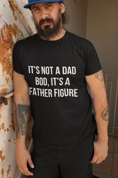 Upgrade your dad's style with our "It's Not a Dad Bod, It's a Father Figure" T-shirt. This soft, comfortable tee combines humor and pride, perfect for the dad who embraces his role with confidence and a smile. Ideal for Father's Day, birthdays, or any day he wants to make a statement. This unisex ultra cotton tee is a classic. The shoulders are tapped for a good upper-body fit. There are no side seams, ensuring a clean, unbroken flow. The collar has ribbed knitting for improved elasticity. The m Funny Quote Print Black Tops, Black Relaxed Fit T-shirt With Quote Print, Summer Black T-shirt With Quote Print, Black Slogan Top For Father's Day, Father's Day T-shirt With Funny Text In Relaxed Fit, Father's Day Black T-shirt With Text Print, Funny Print Tops For Father's Day, Funny Crew Neck Top For Father's Day, Father's Day Crew Neck Top With Funny Print