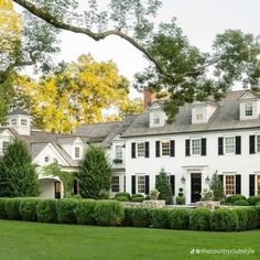 a large white house surrounded by lush green grass