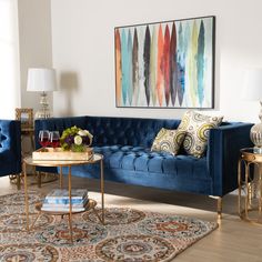 a living room with blue velvet couches and rugs in front of a painting on the wall