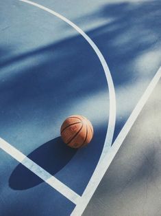 a basketball sitting on top of a blue court