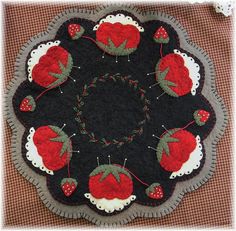 a close up of a black and red table cloth with cherries in the center