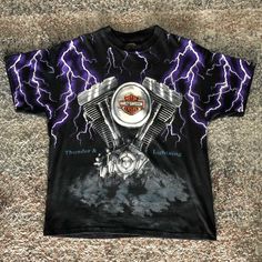 a harley davidson t - shirt on the ground with lightning in the sky behind it