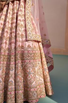 Blush pink lehenga with zardozi embroidery using silken threads, dabka, cutdana and sequins. Comes with embroidered blouse and two embroidered dupattas.
Component: 4
Pattern: Embroidered
Type Of Work: Zardozi, silken threads, dabka, cutdana and sequins
Neckline: Plunged Neck
Sleeve Type: Short
Fabric: Raw Silk
Color: Pink
Other Details: 
Broad leaf shaped neckline
Back cut-out with tassel tie-up
Semi-sheer dupattas with embroidery
Occasion: Bride, Wedding - Aza Fashions Pastel Bridal Lehenga, Pastel Lehenga, Zardozi Embroidery, Pink Lehenga, Bridal Lehenga, Embroidered Silk, Bride Wedding, Embroidered Blouse, Raw Silk