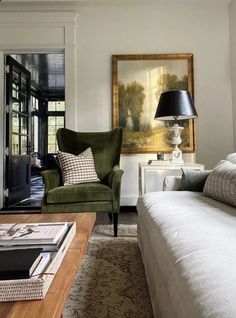 a living room filled with furniture and a painting hanging on the wall above it's headboard