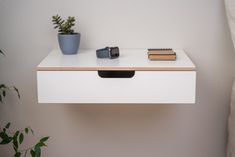 a white table with some books and plants on it