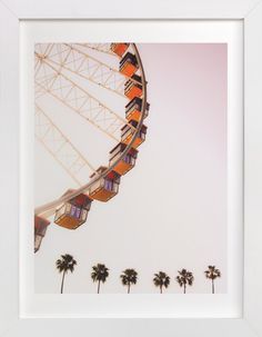 a ferris wheel with palm trees in the foreground and a white frame around it