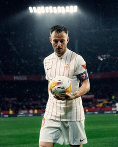 a man holding a soccer ball on top of a field