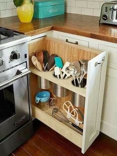 a kitchen with an oven and some utensils on the shelf in front of it