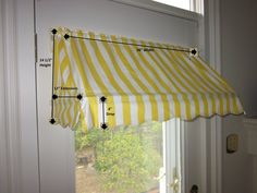 a yellow and white striped awning in front of a door with measurements on it