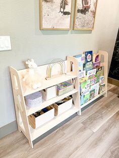 two children's bookshelves in the corner of a room with pictures on the wall