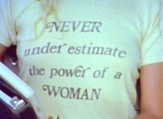 a woman wearing a t - shirt that says never underestimate the power of a woman