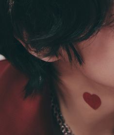 a woman with a red heart tattoo on her chest