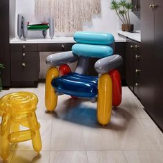 an inflatable chair sits on the kitchen floor next to a stool and potted plant