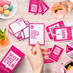 pink and white business cards with the words never have ever printed on them are being held by a woman's hand