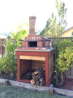 an outdoor wood burning oven with logs in the foreground