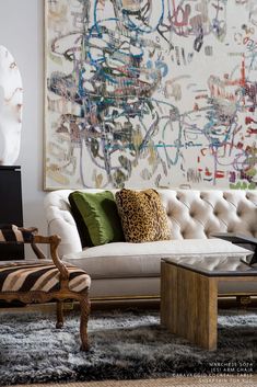 a living room filled with furniture and a painting on the wall