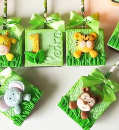 four baby's first birthday decorations in the shape of animals on grass with green ribbons