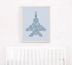 a white crib with a blue poster hanging on the wall