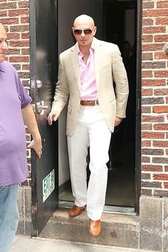 a man standing in an open doorway with his hand on the door's handle