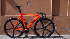 an orange bike parked on the side of a building