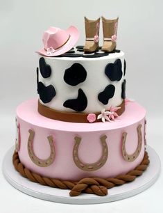 a pink and black cake with cowgirl boots on top