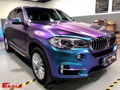 a purple and blue bmw suv parked in a garage