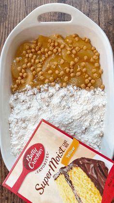 some kind of cake sitting on top of a white plate next to a bag of cereal